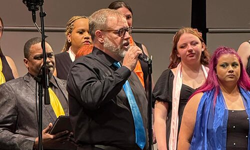 A soloist singing while stainding in front of the choir.